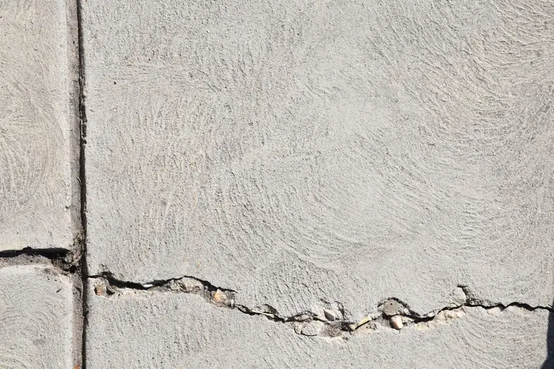 Swirl-finished concrete slab with a jagged crack running out from a control joint