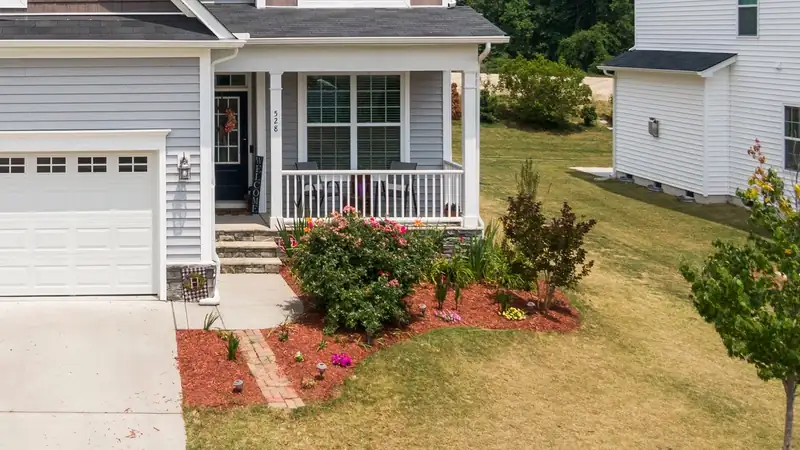 Concrete front walk branching off a driveway toward the entry steps of a suburban home