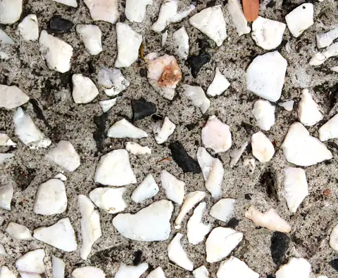Seeded decorative concrete surface with white marble chips and dark stones in a gray matrix